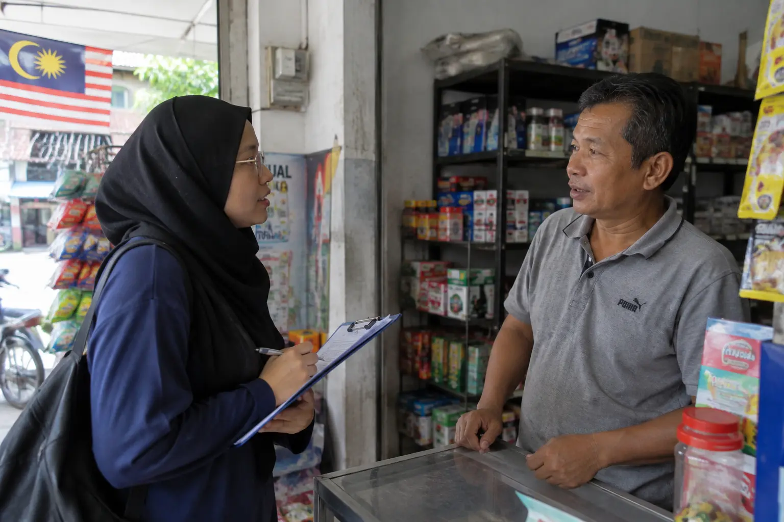 Penyelidik menemu bual pemilik kedai kecil di dalam kedai runcit, mewakili kajian kes PKS tunggal